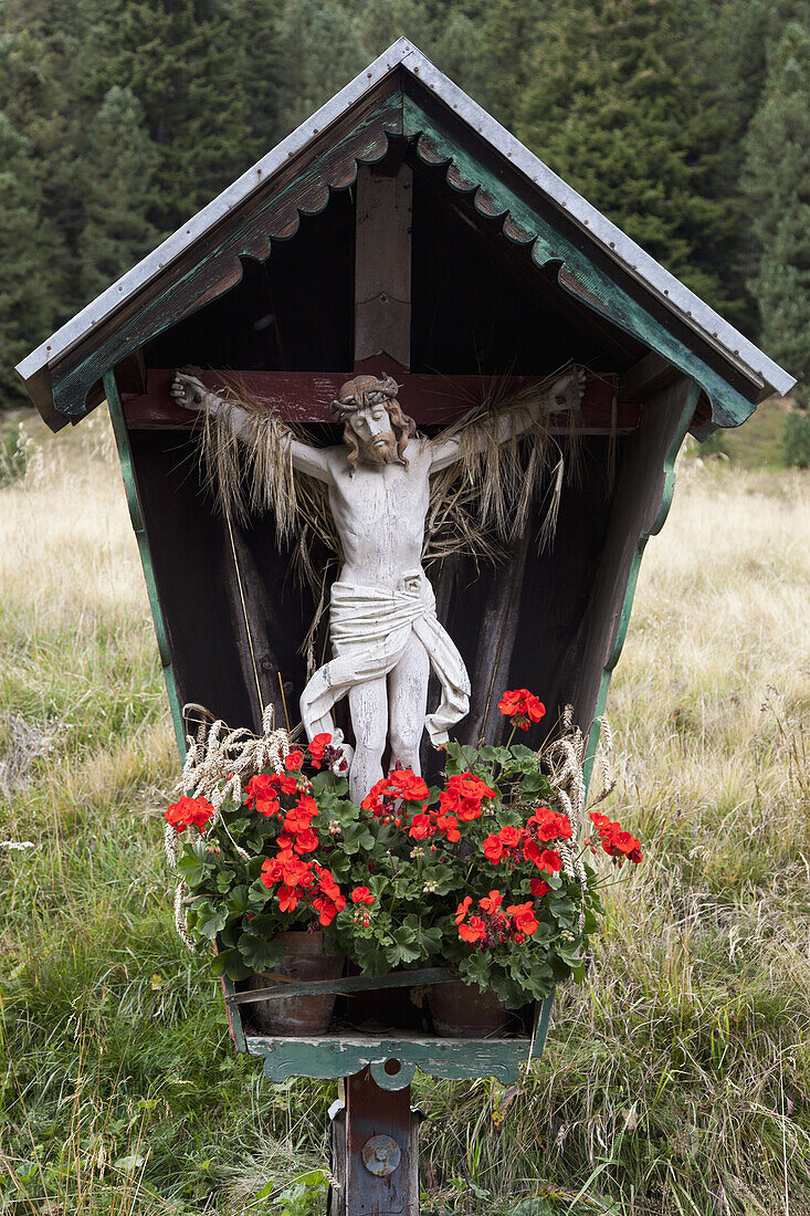 A crucifix and flowers in a wooden structure