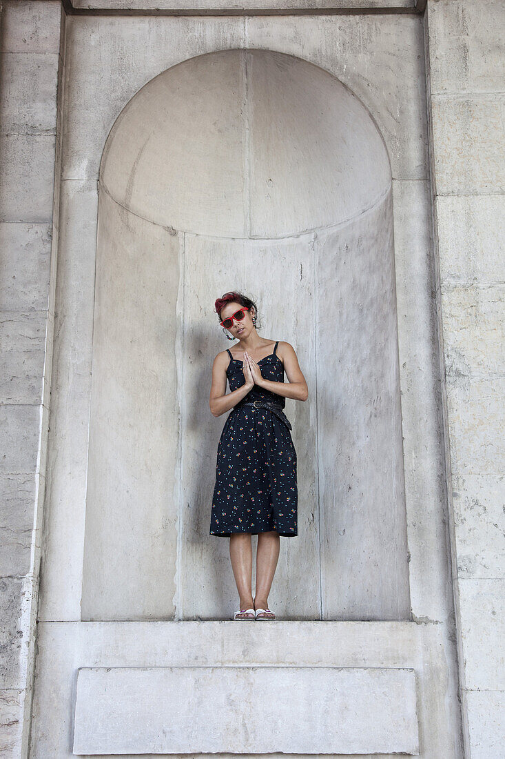 A woman standing in an apse and praying