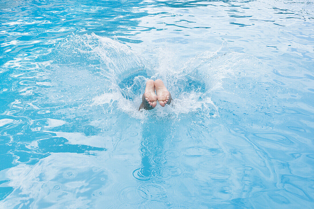 Detail of a boy diving into a swimming pool