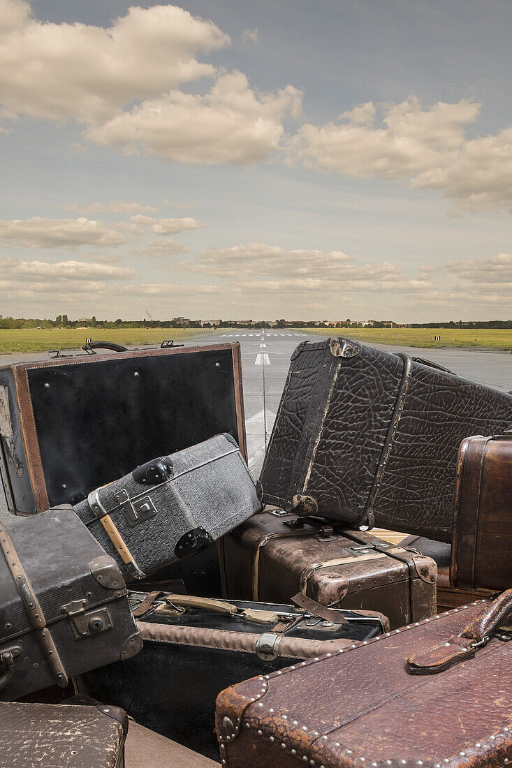 Old suitcases on street against sky