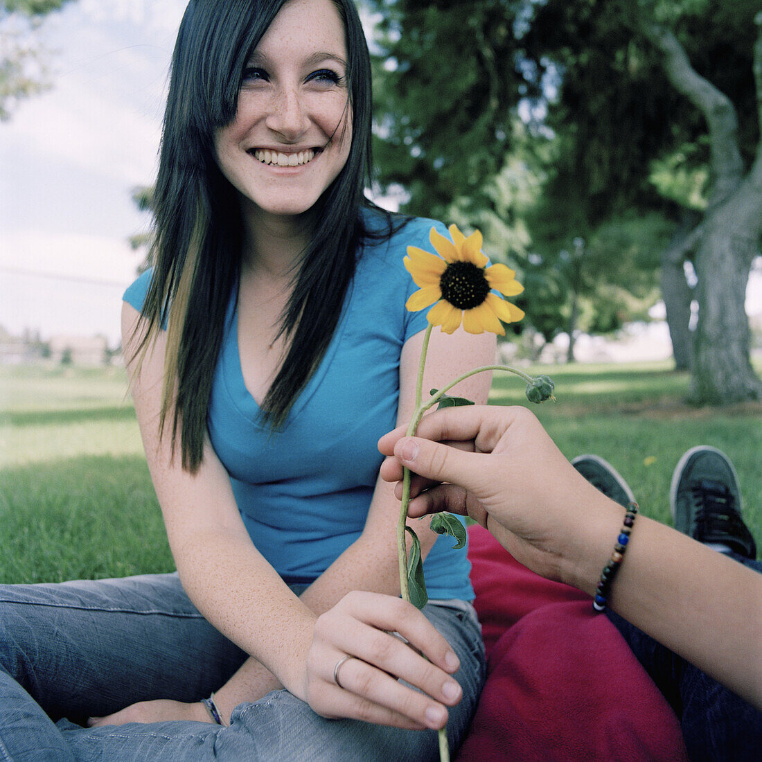 A young woman receiving a daisy