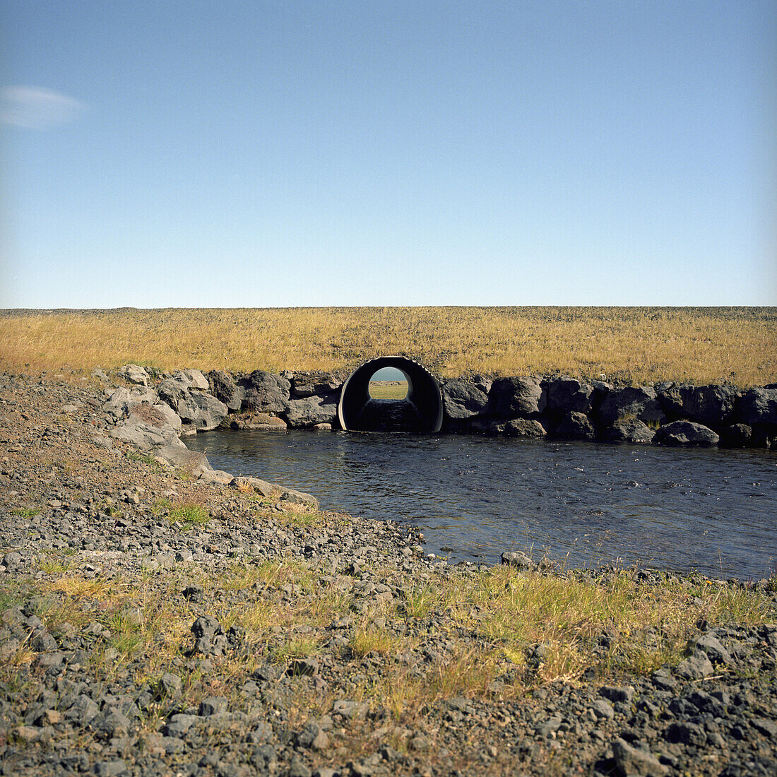 A culvert pipe carrying water for a stream under a field