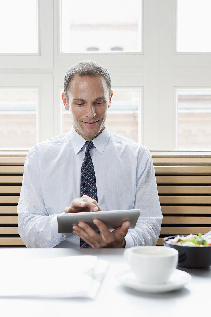 A businessman using a digital tablet on his lunch break