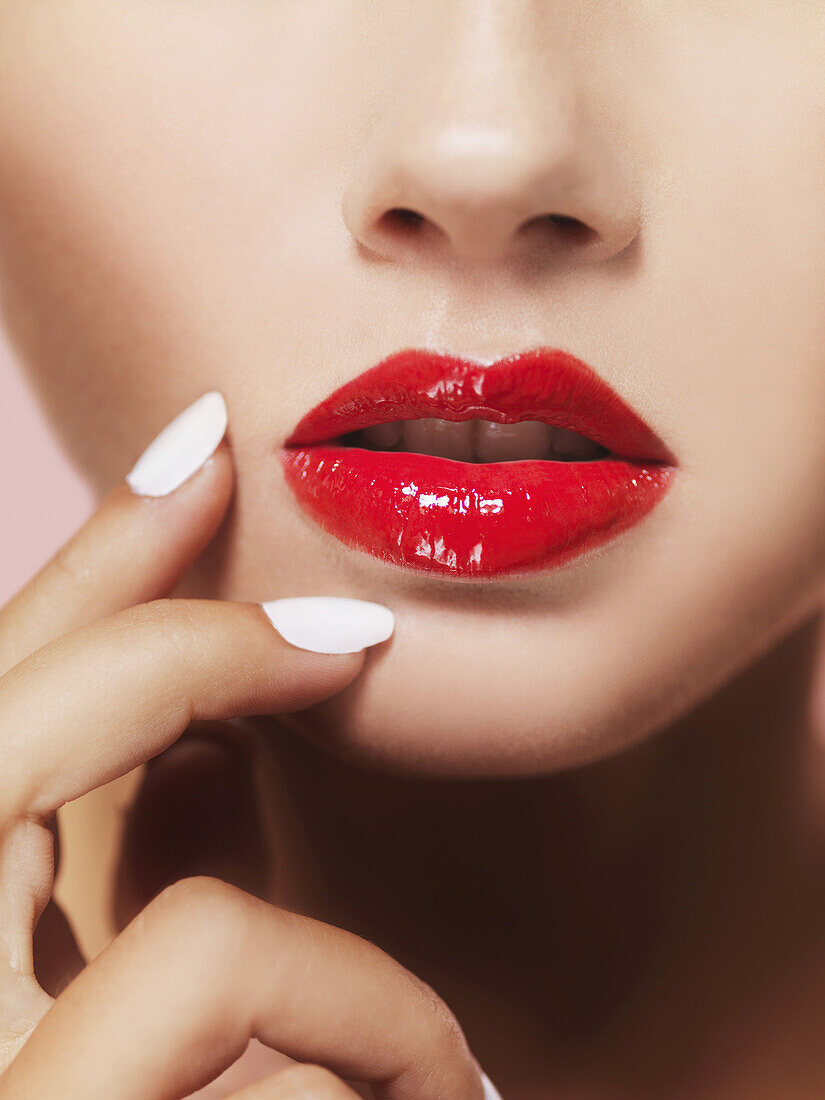 Die Lippen einer Frau mit leuchtend rotem Lippenstift, Nahaufnahme des Mundes