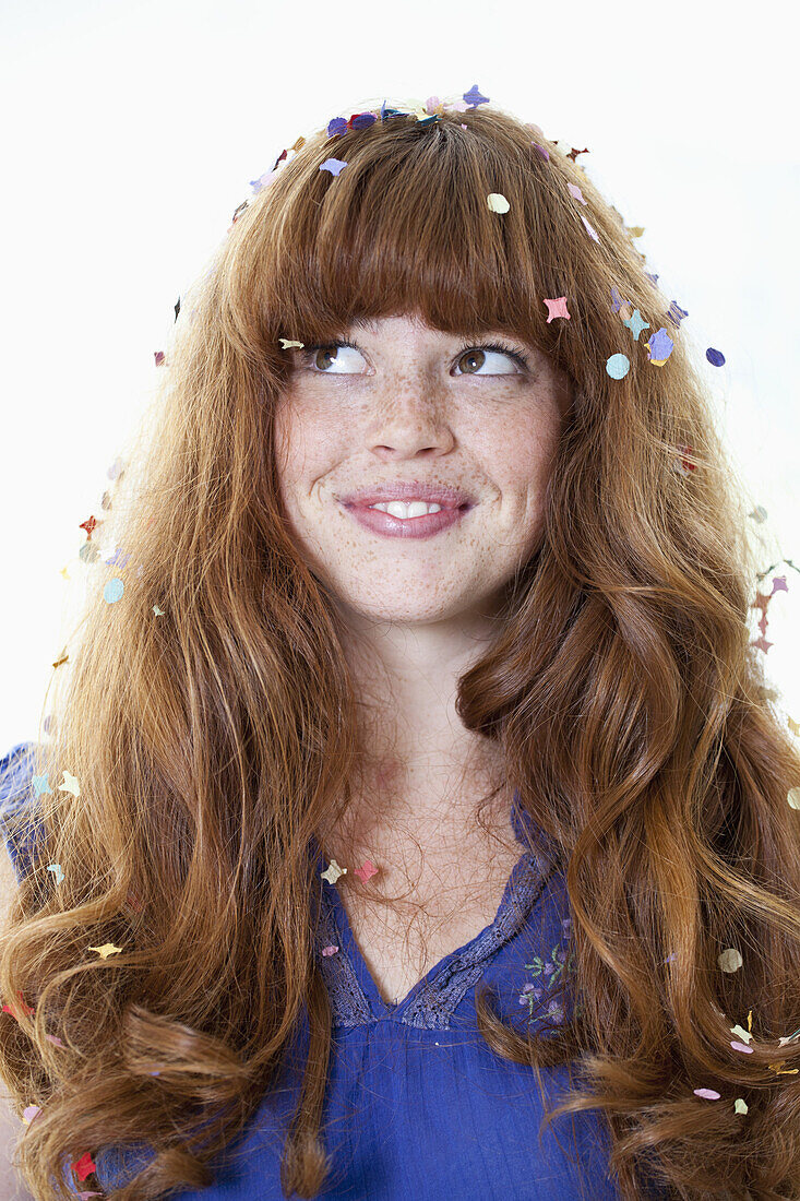 A smiling young woman with confetti in her hair
