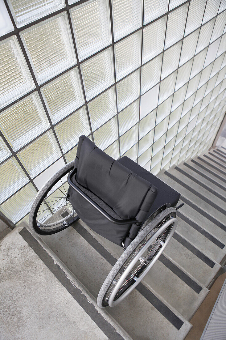 Wheelchair placed precariously at the top of stairs