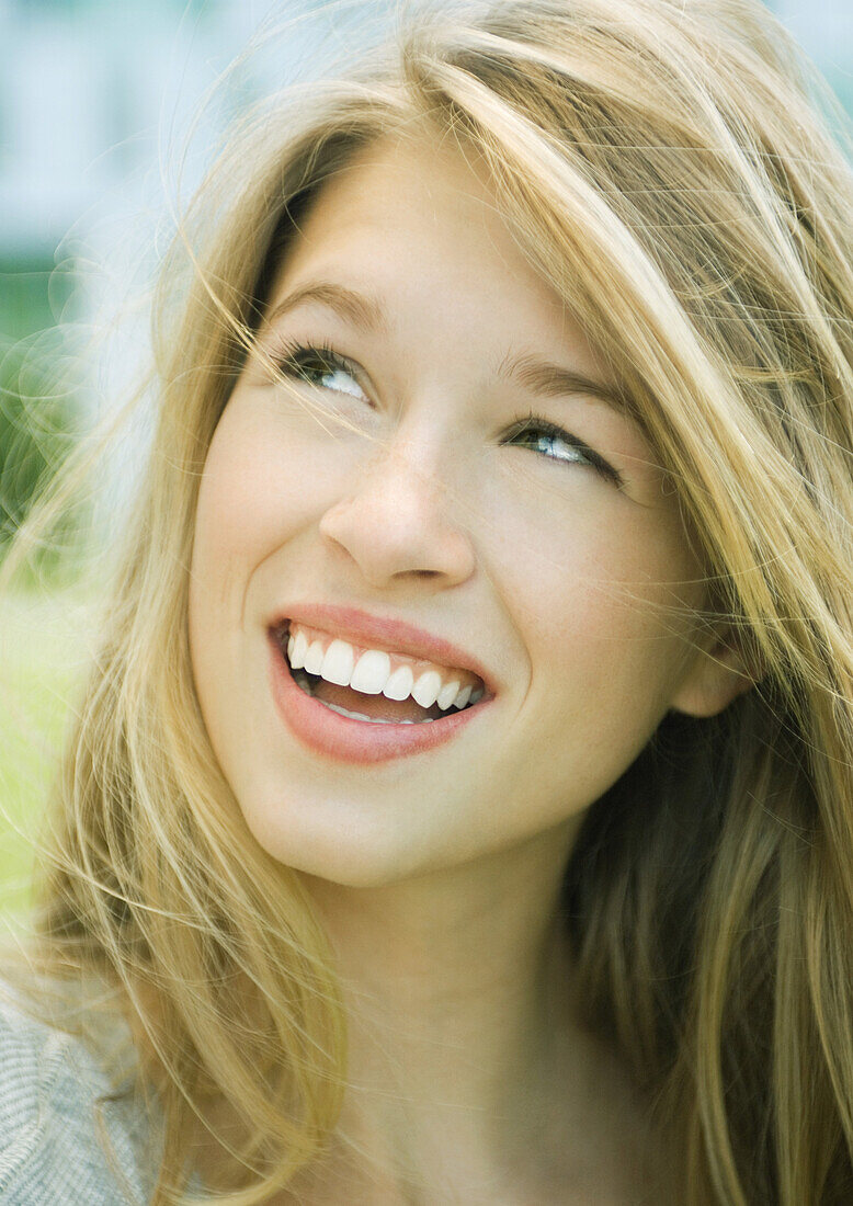 Young woman smiling and looking up, portrait