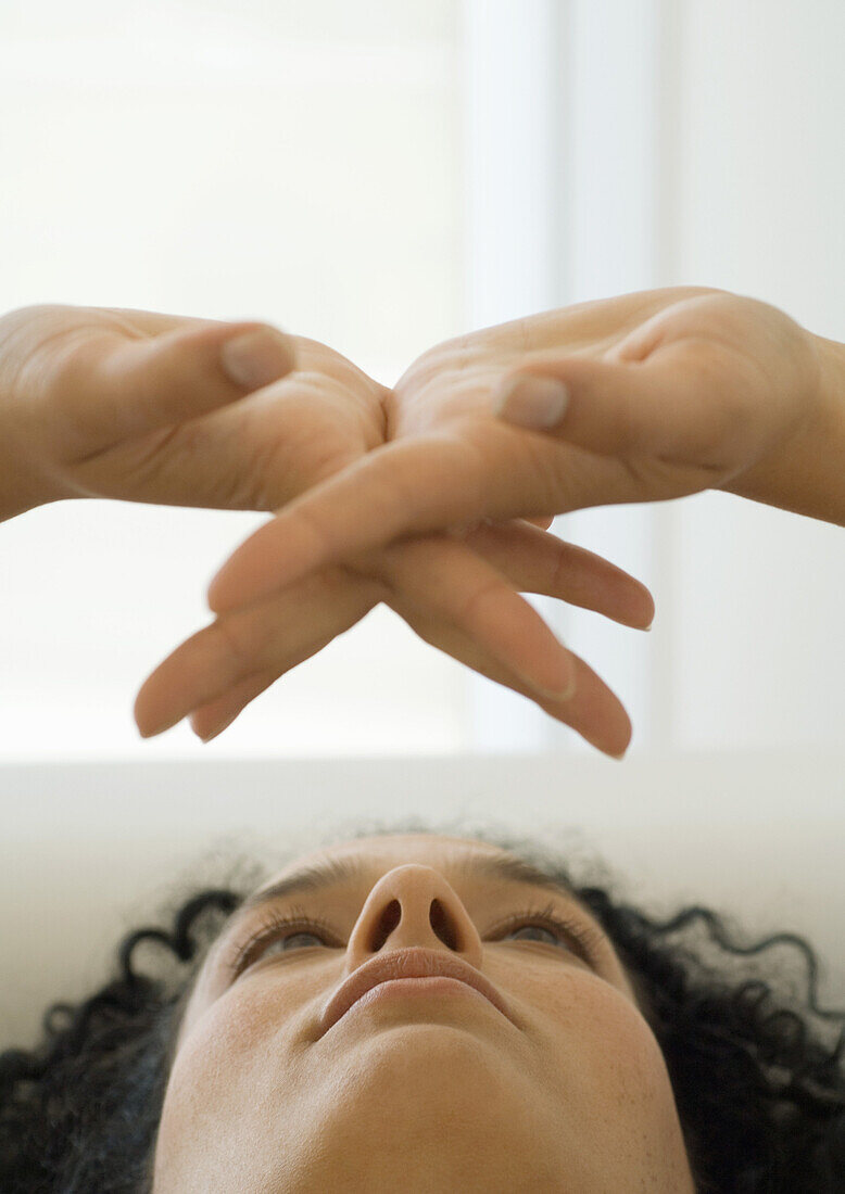 Woman looking at her clasped hands, close-up