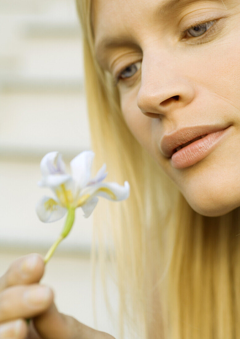 Woman looking at flower, close-up