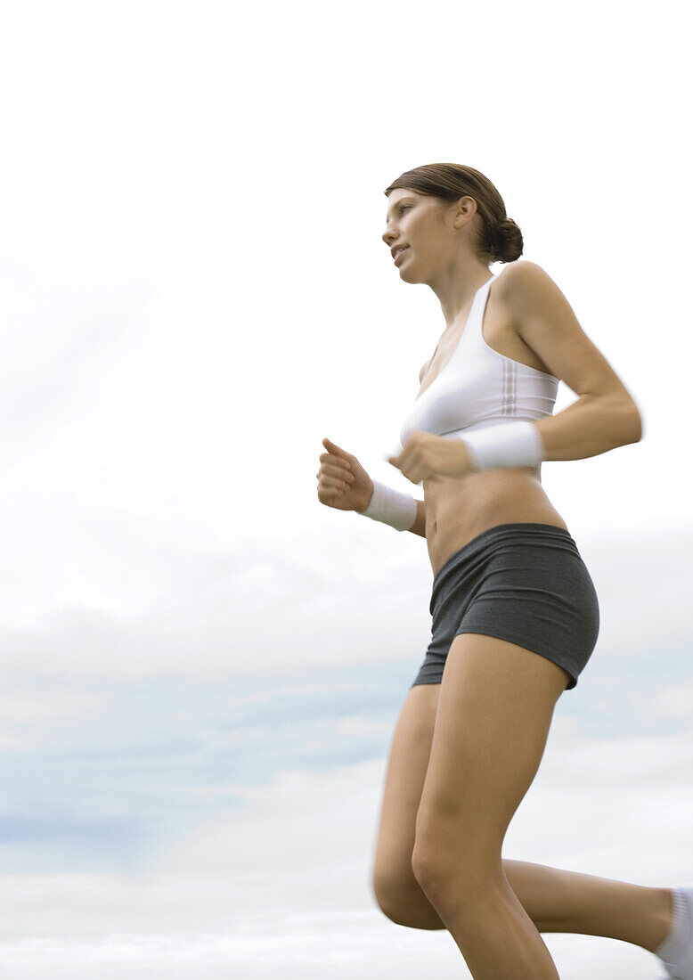 Young woman jogging, low angle view