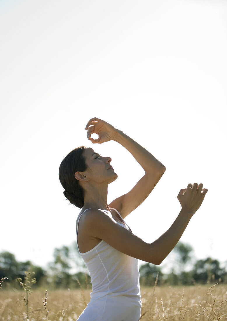 Frau in Yogastellung auf einem Feld