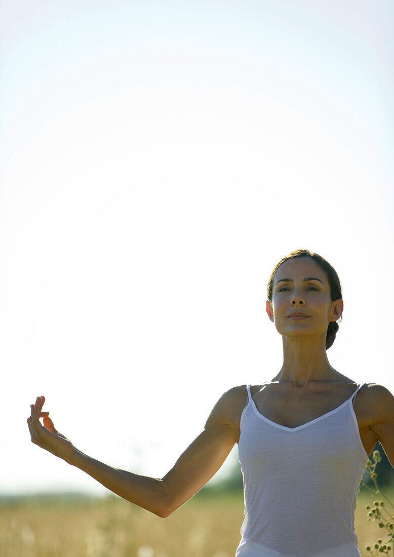 Woman doing yoga pose in field