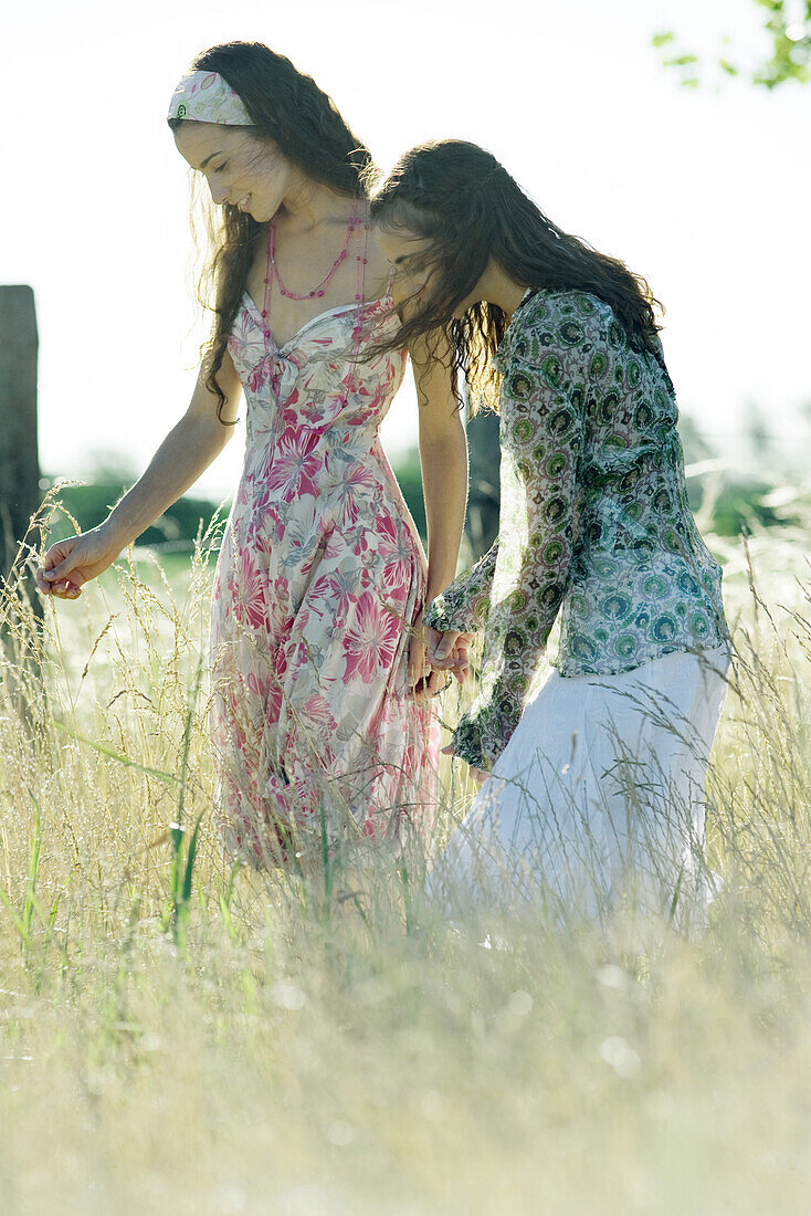 Two young women standing in field