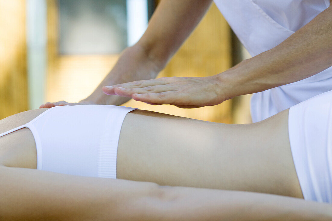 Therapist's hand hovering over patient's back