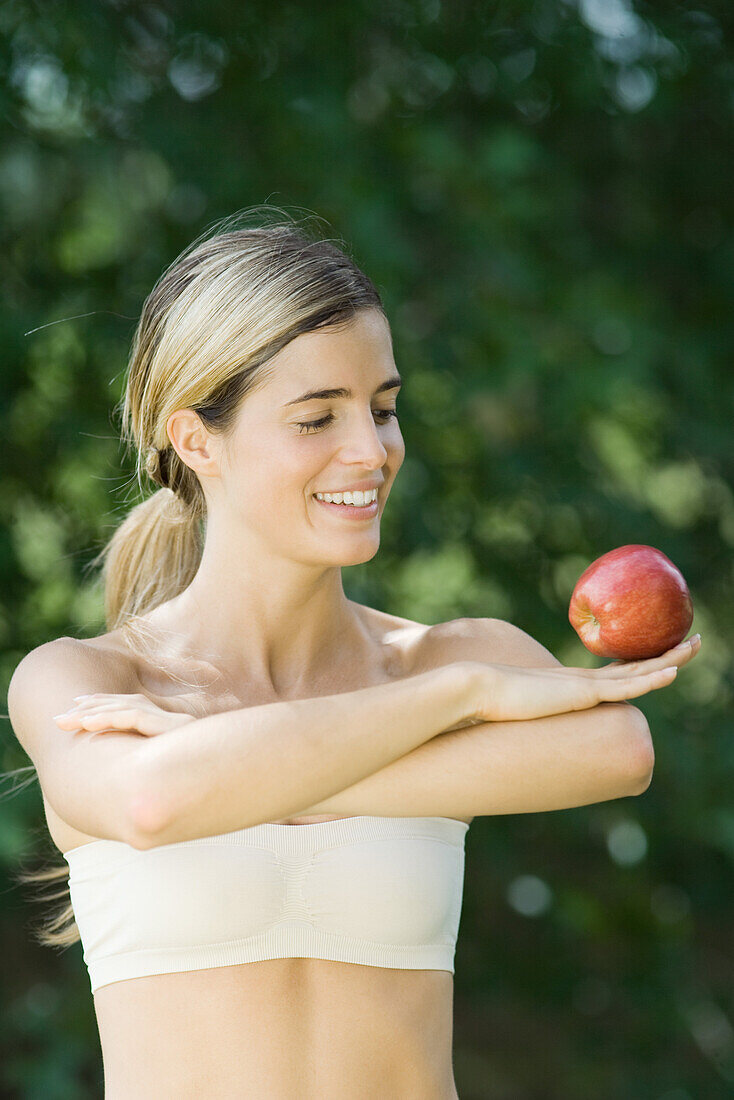 Woman balancing apple on back of hand