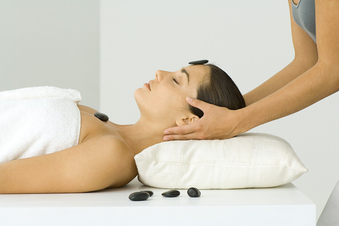 Woman receiving massage and lastone treatment, close-up