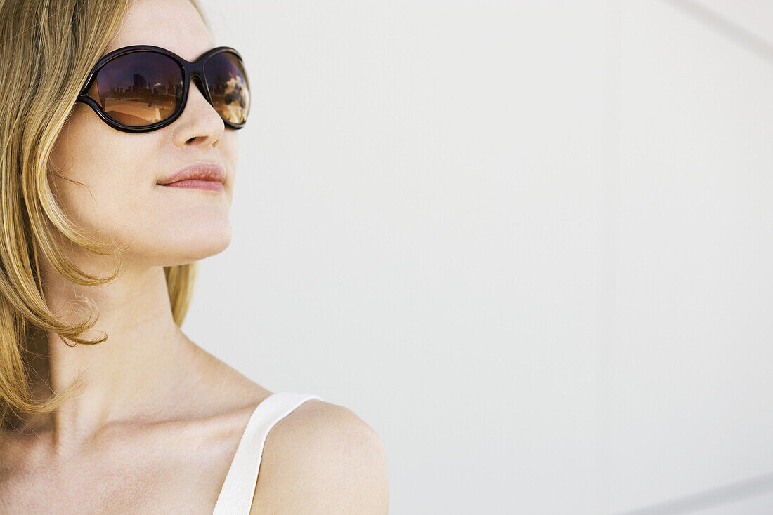 Woman wearing sunglasses, looking away, portrait