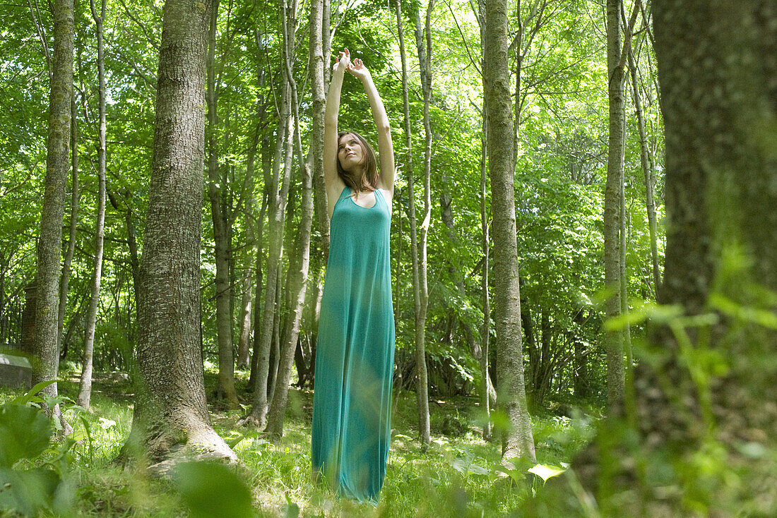 Young woman stretching in woods