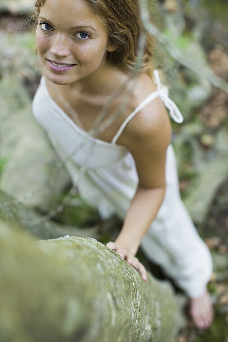 Young woman standing by trees, high angle view