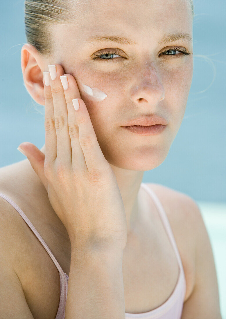 Woman applying sunscreen