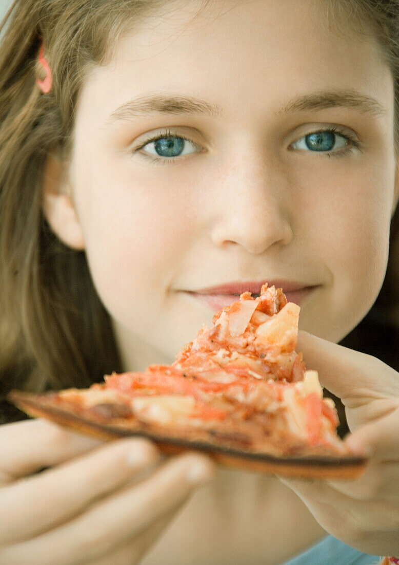 Girl holding slice of pizza