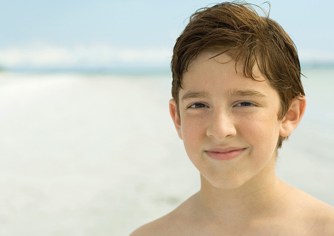 Boy smiling on beach, portrait