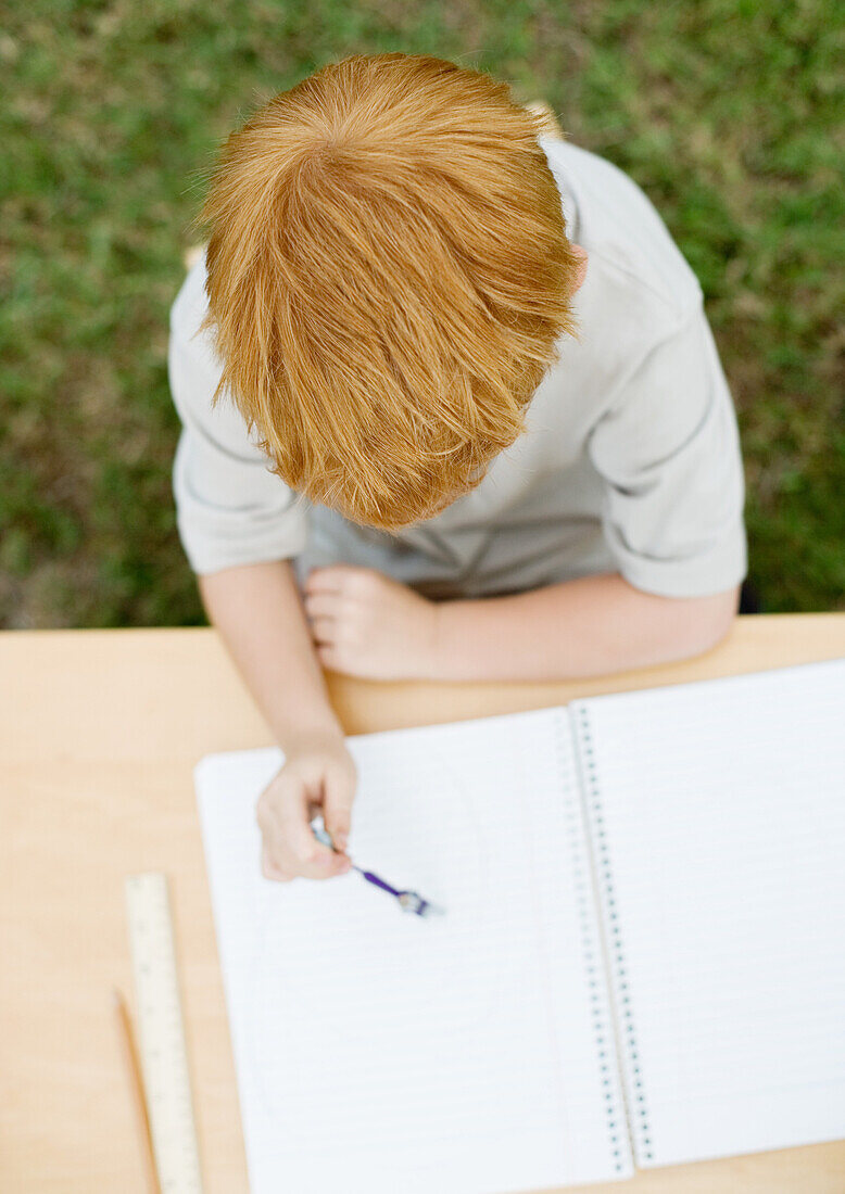 Boy sitting with open notebook
