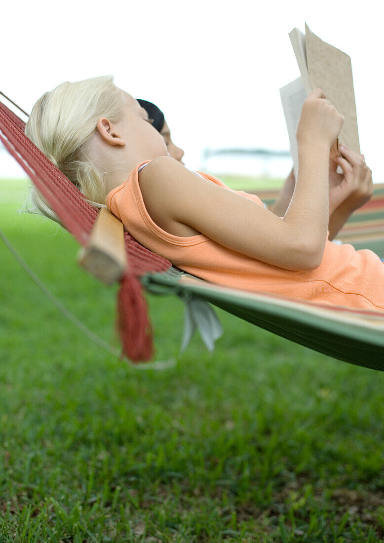 Two girls reading in hammock together