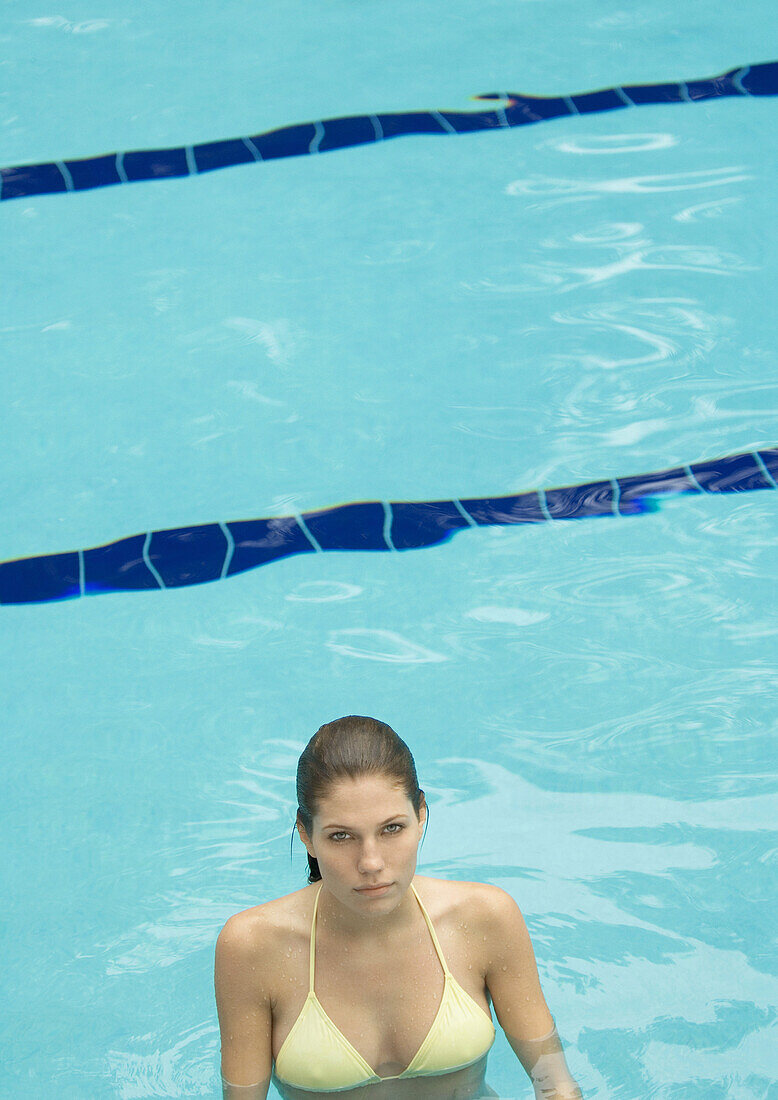 Woman standing in pool, looking at camera
