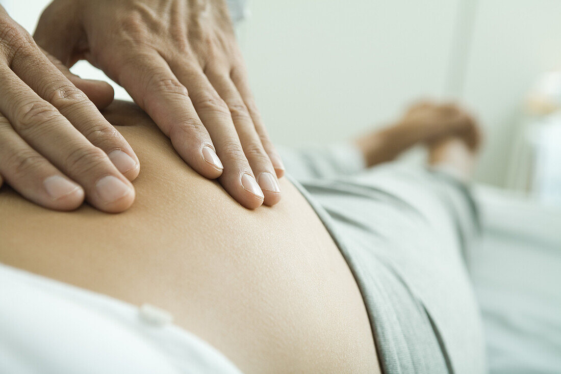 Man's hands on pregnant woman's stomach
