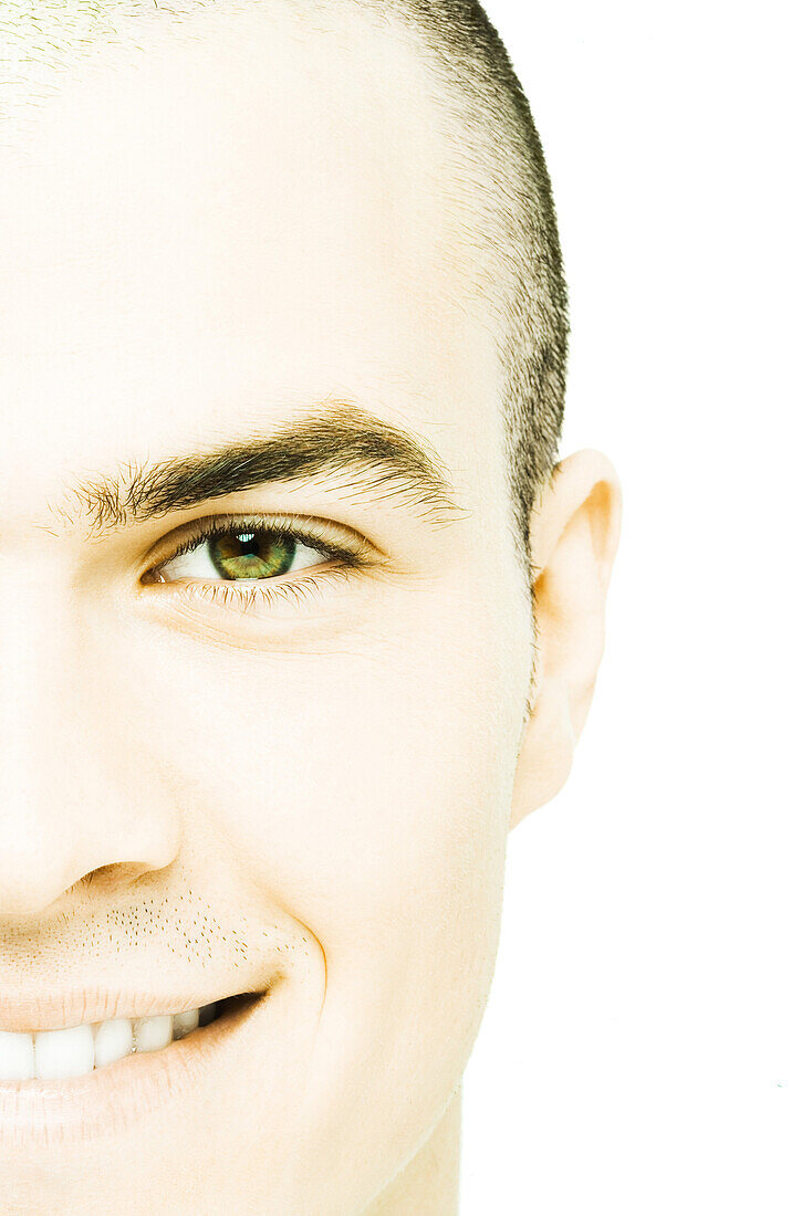 Young man smiling at camera, close-up