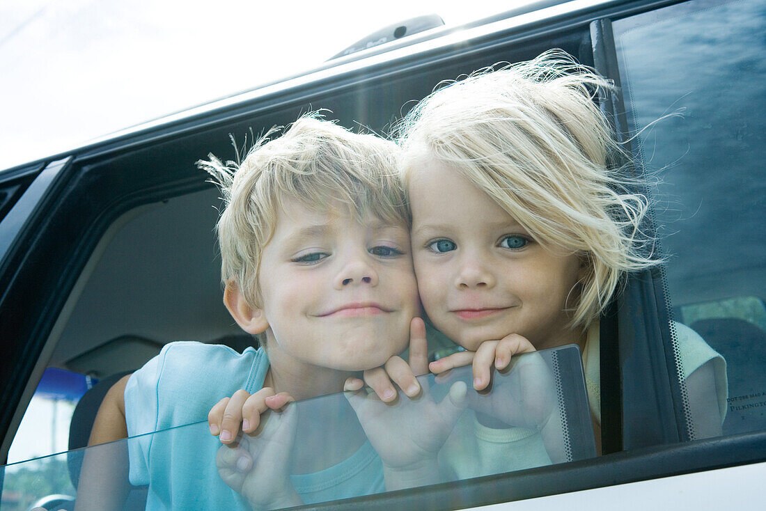Children sticking heads out of car window