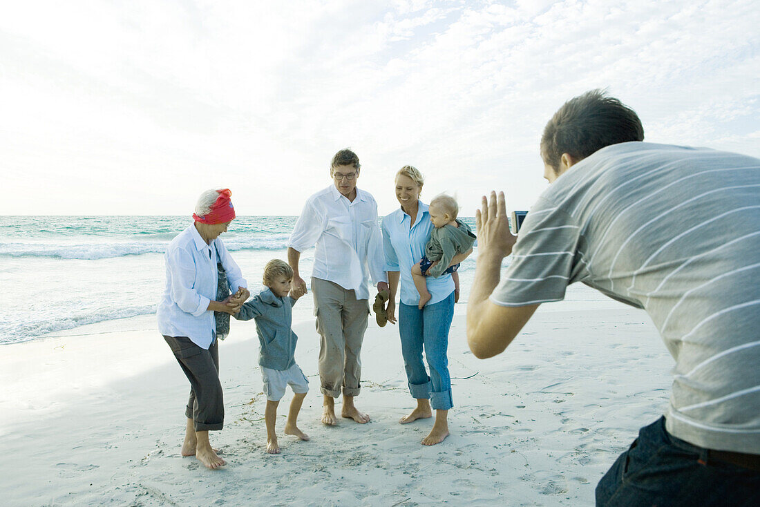 Family on beach, man taking photo