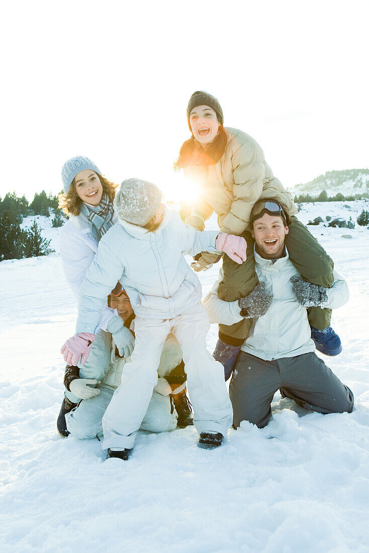 Young friends playing around in snow, group photo