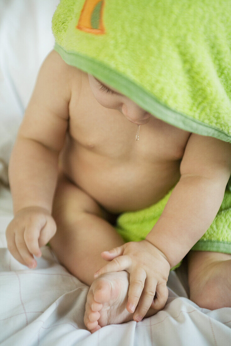 Baby wrapped in towel after bath, drooling