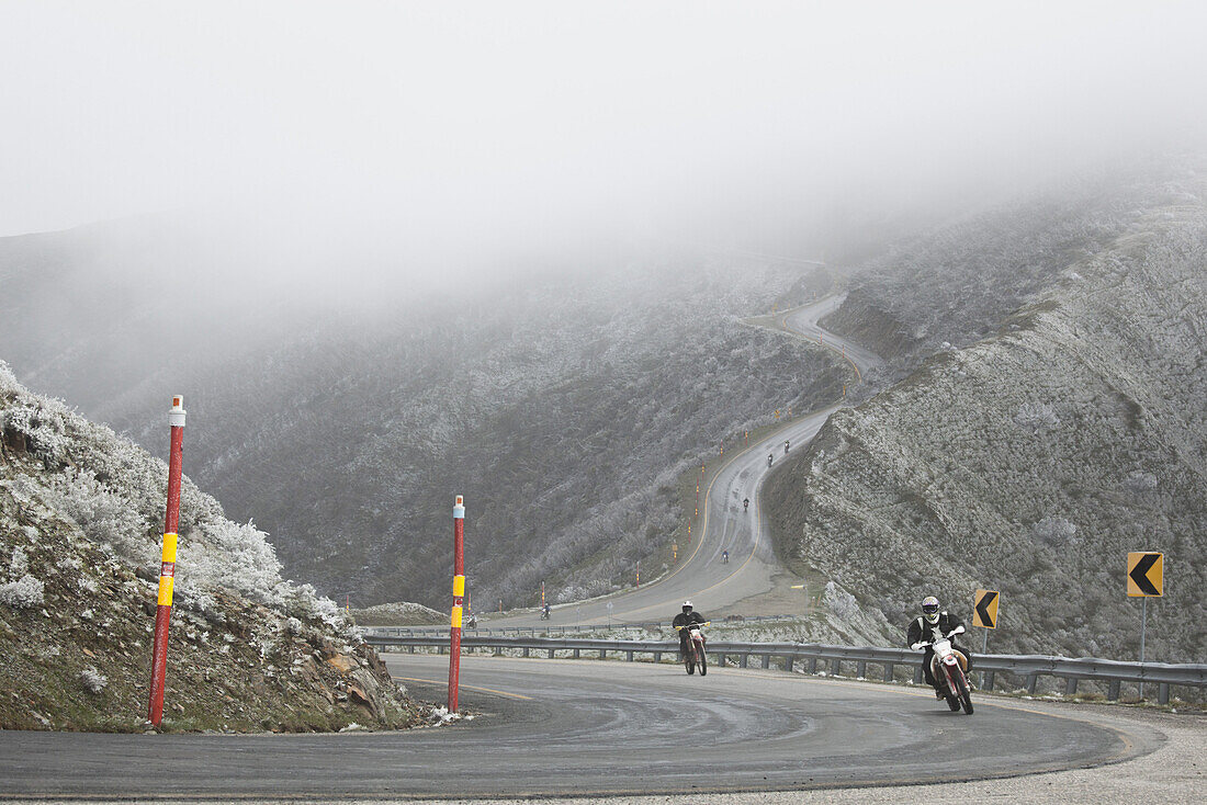 Motorcycle race on mountain road in foggy weather