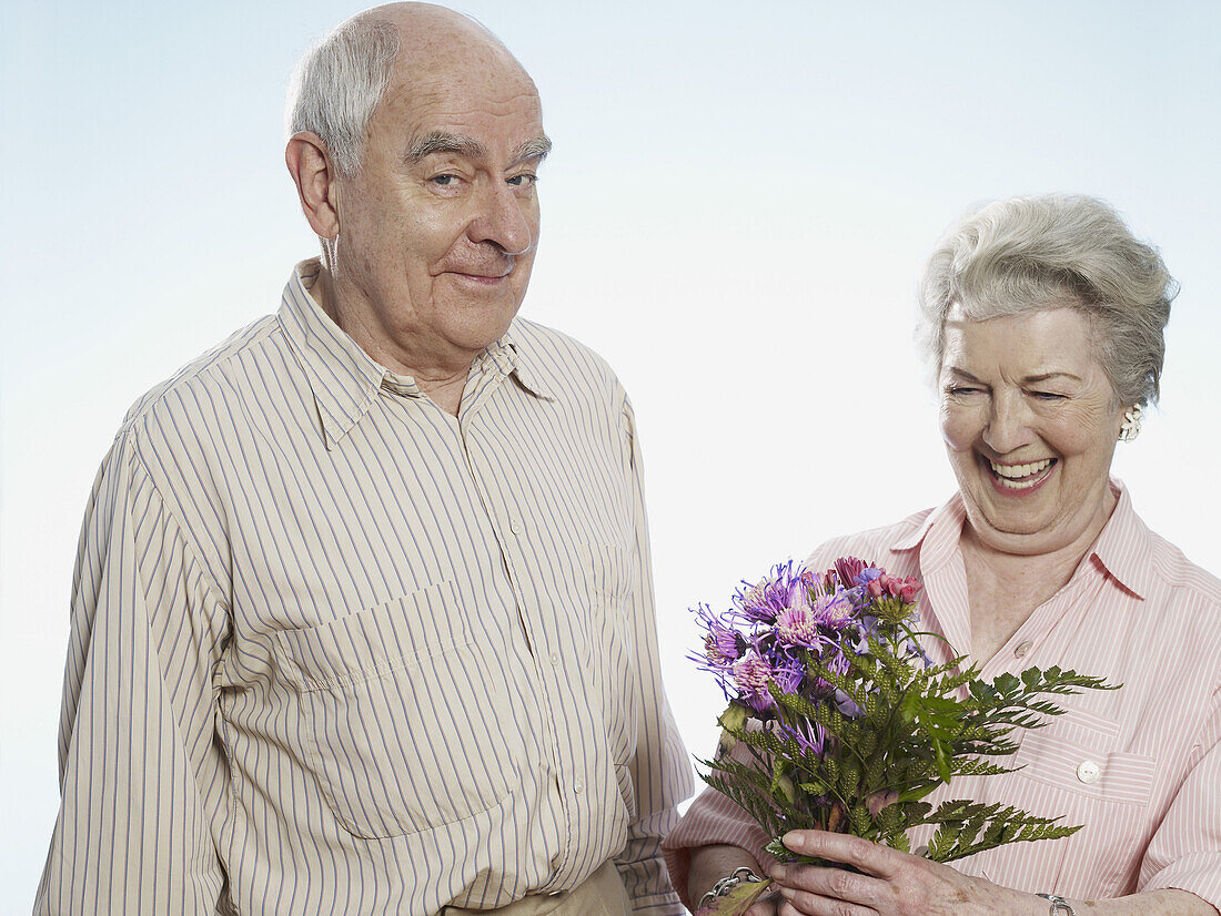 Senior man knows she's happy when he gives her flowers