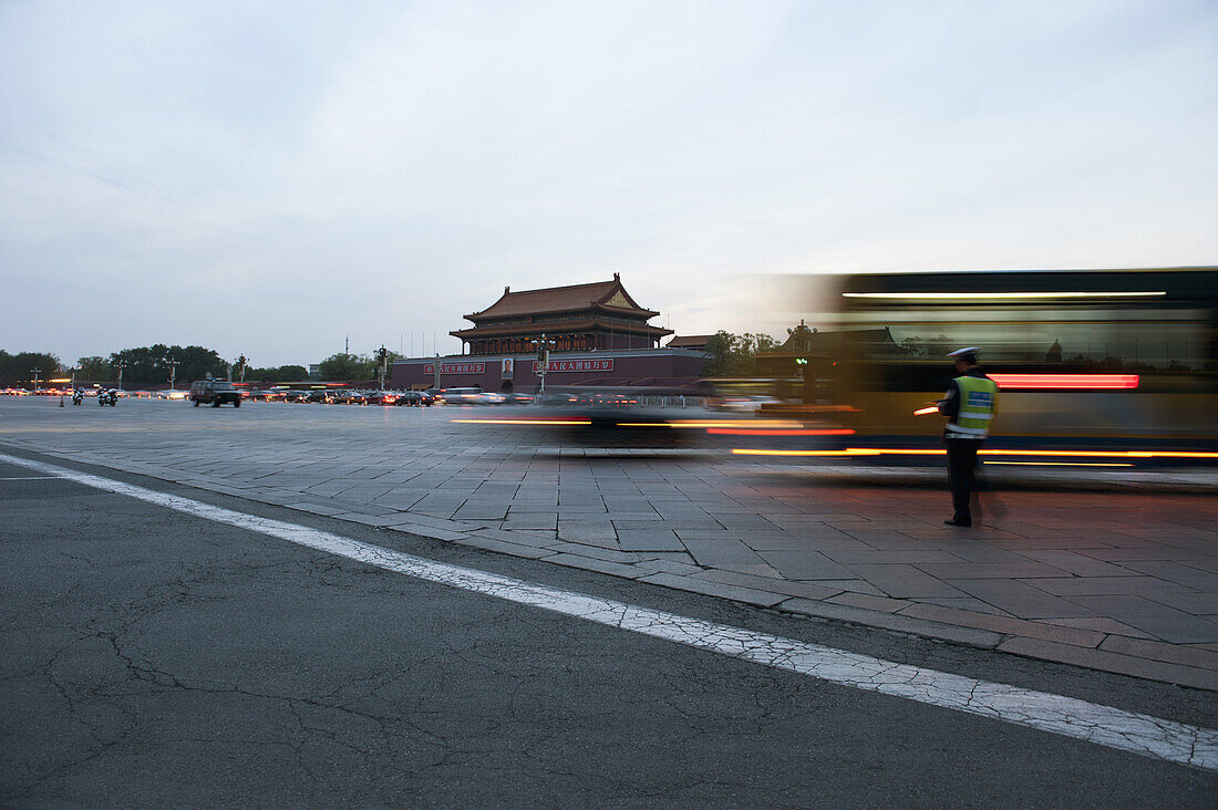 Traffic warden beside moving traffic in Tiananmen Square, Beijing