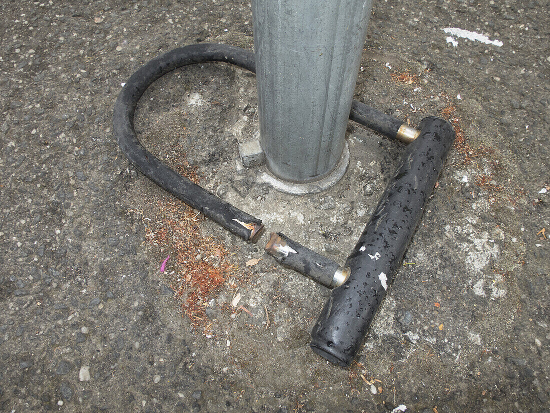 High angle view of broken bicycle lock in pole