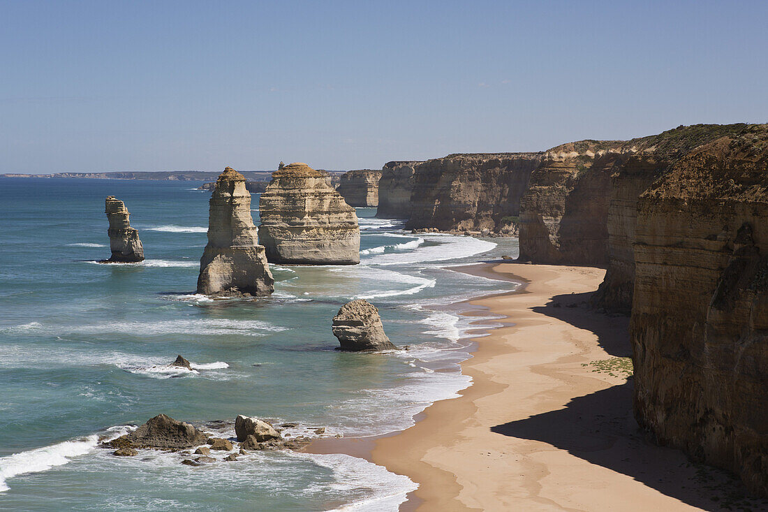 View of rock formations at beach against clear sky