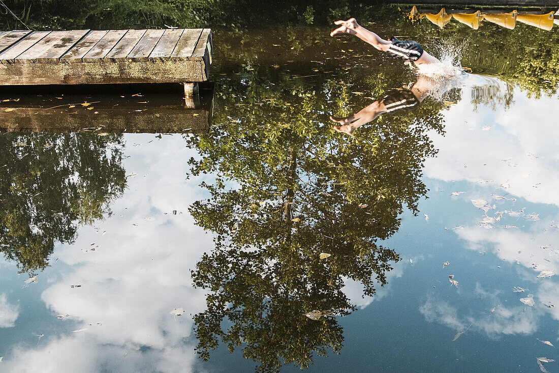Low section of boy diving into lake