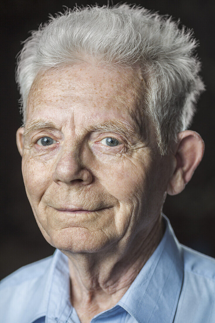 Close-up portrait of happy senior man over black background