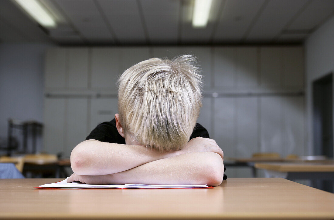 A small boy takes a nap while studying