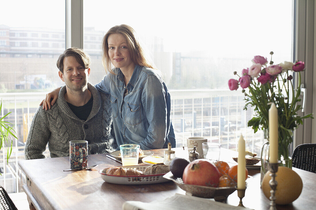 Couple sitting at dining table with breakfast