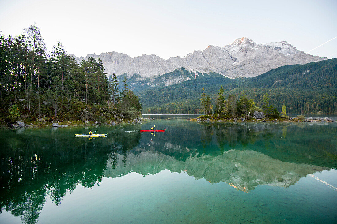 Kayaker paddling on lake Eibsee below Zugspitze, Grainau, Bavaria, Germany