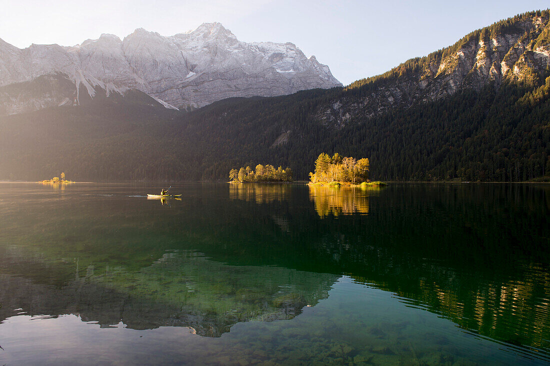 Kayaker paddling on lake Eibsee below Zugspitze, Grainau, Bavaria, Germany