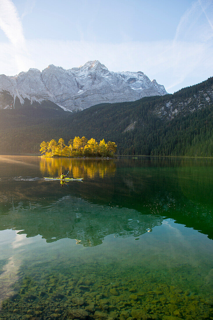 Kayaker paddling on lake Eibsee below Zugspitze, Grainau, Bavaria, Germany