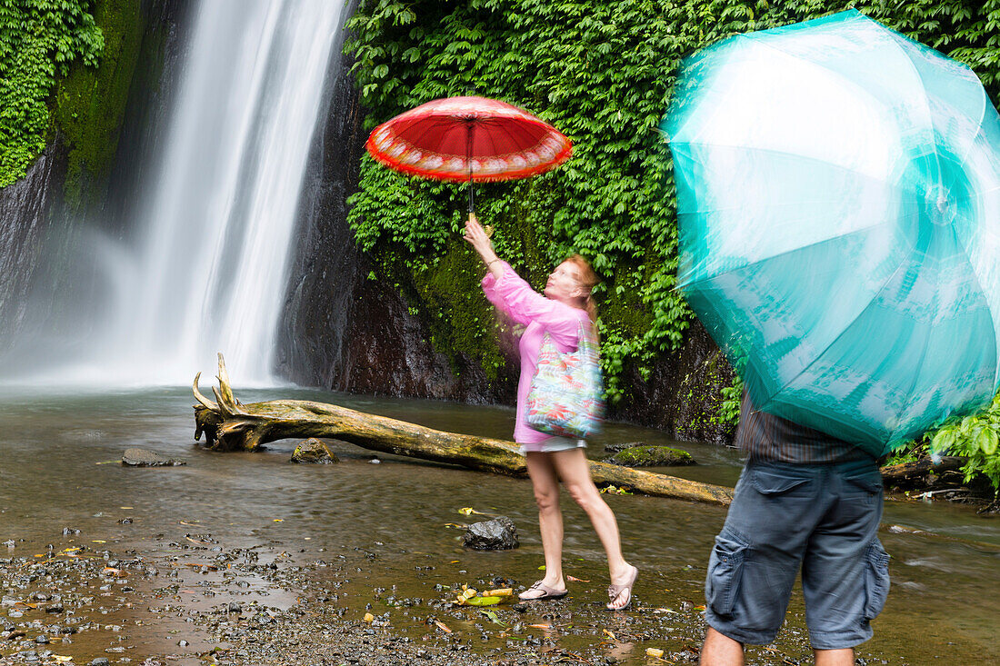 Touristen mit Regenschirmen am Air Terjun Munduk Wasserfall, Munduk, Bali, Indonesien