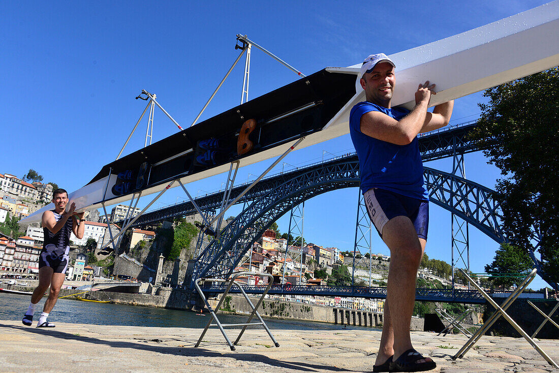 Men carrying a rowing boat, At the Ponte Luis over Rio Douro, Porto, Portugal