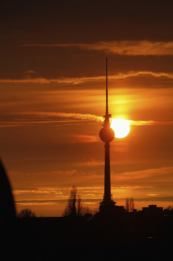 The Alexanderplatz television tower silhouetted against a beautiful sky with the sun setting